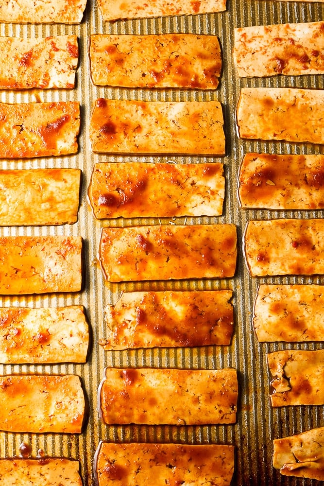 marinated tofu on a baking sheet getting ready to be baked.