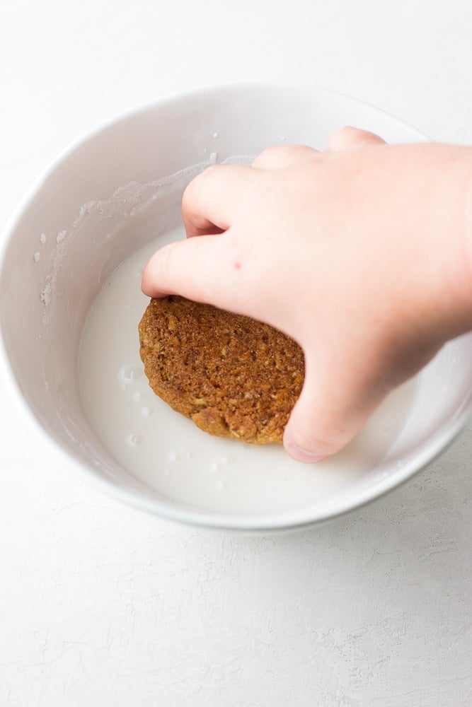 cookie being dipped into icing