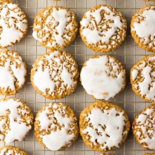 lots of iced vegan oatmeal cookies on a cooling rack