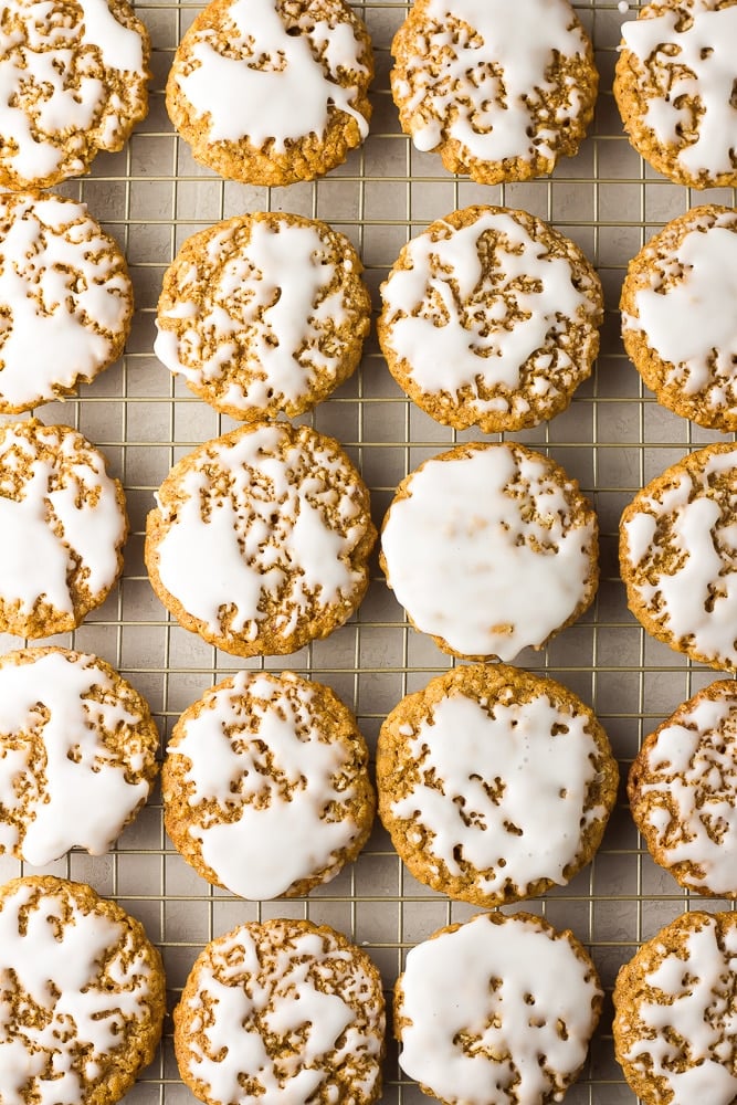 lots of iced vegan oatmeal cookies on a cooling rack