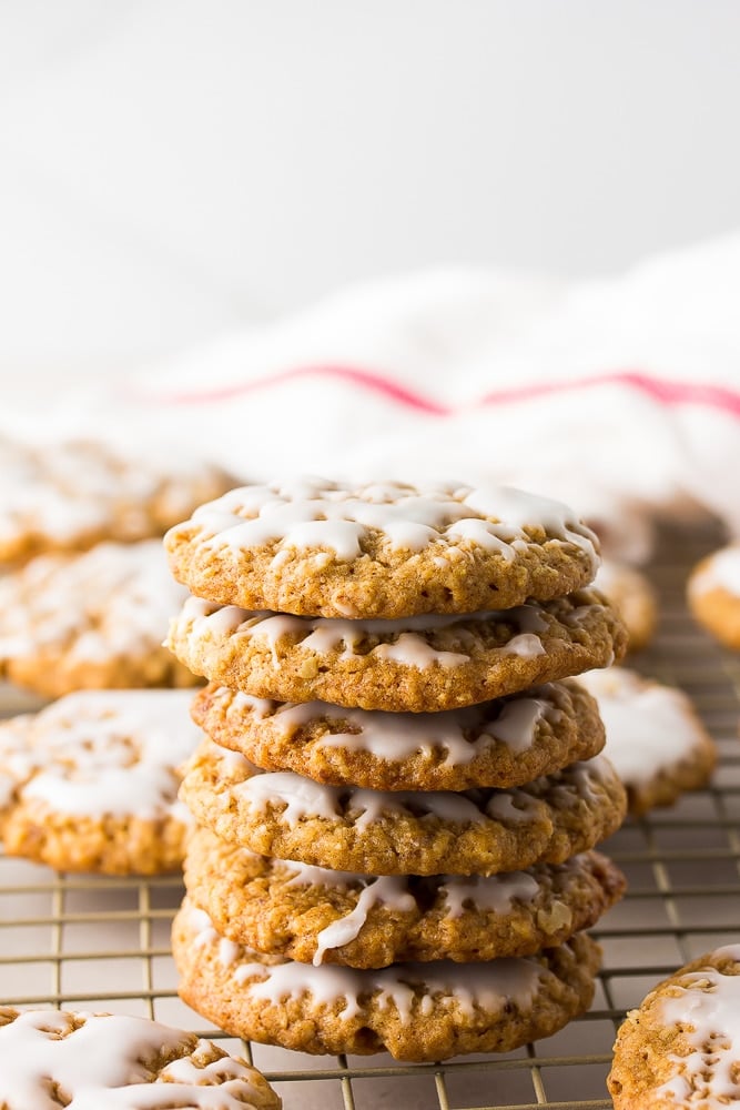 stack of iced vegan oatmeal cookies, red/white towel in background.