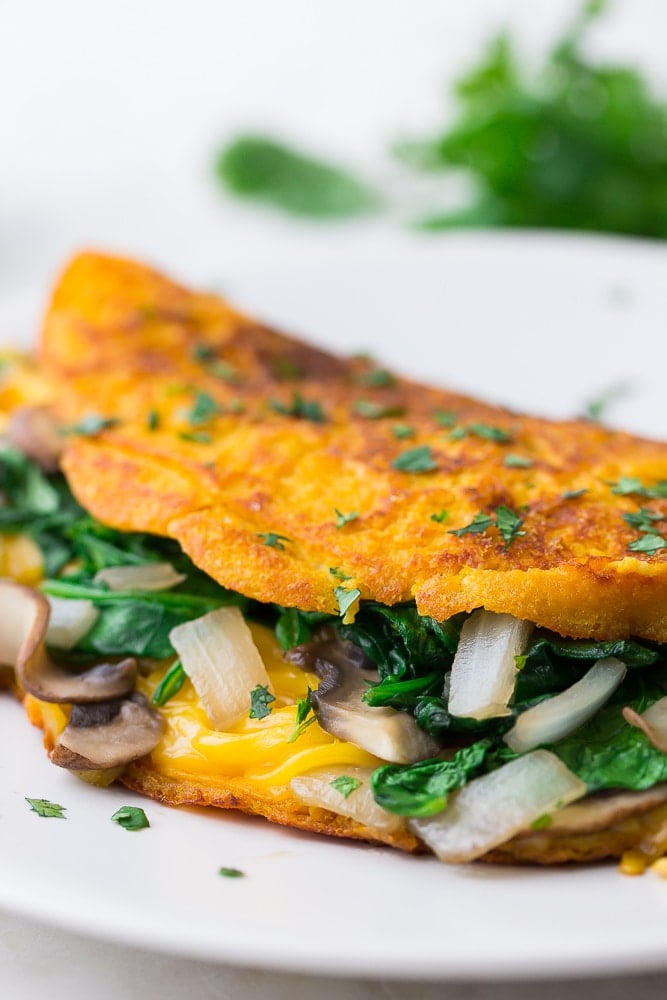 close up of vegan omelette with veggies and cheese inside