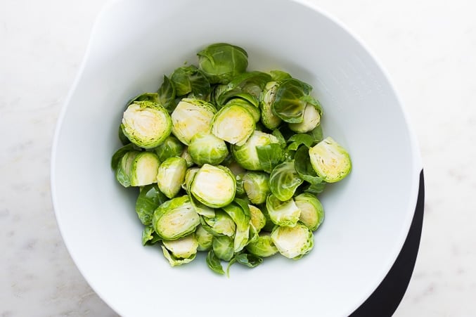 white bowl with halved brussels sprouts in it