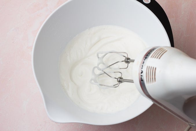 mixer in bowl with chickpea liquid, fluffy