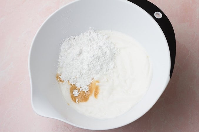 powdered sugar and vanilla added to bowl with whipped cream