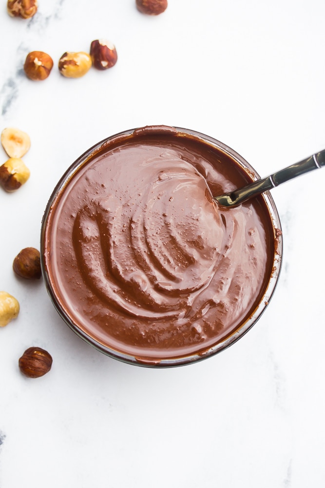 small glass bowl with nutella and knife in it