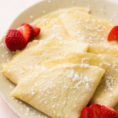 plate of vegan crepes, folded with berries