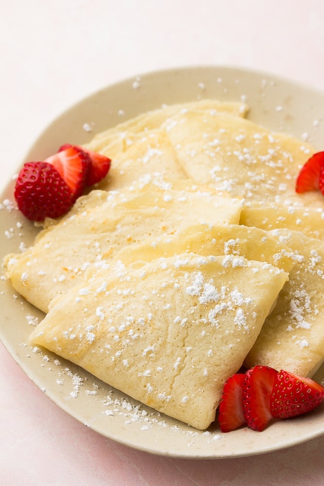 plate of vegan crepes, folded with berries