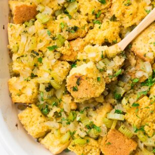 looking down on cornbread stuffing casserole with wooden spoon in it