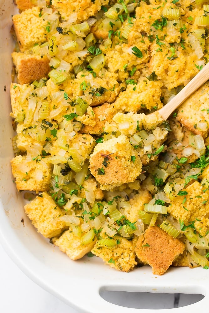 looking down on cornbread stuffing casserole with wooden spoon in it