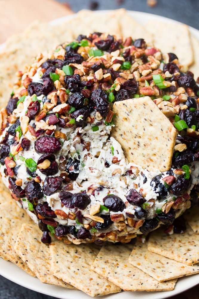 vegan cranberry pecan cheese ball with a cracker in it