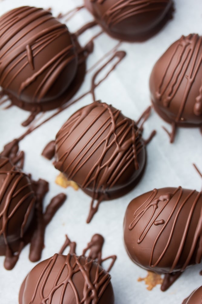 close up of vegan chocolate peanut butter balls on parchment paper