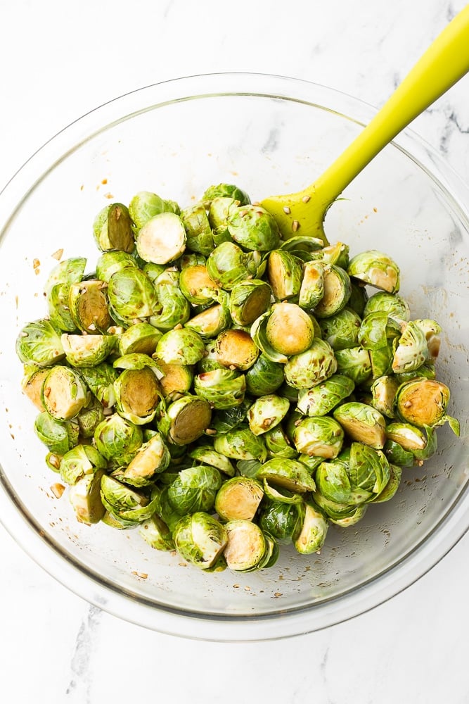 brussels sprouts coated in sauce before being roasted