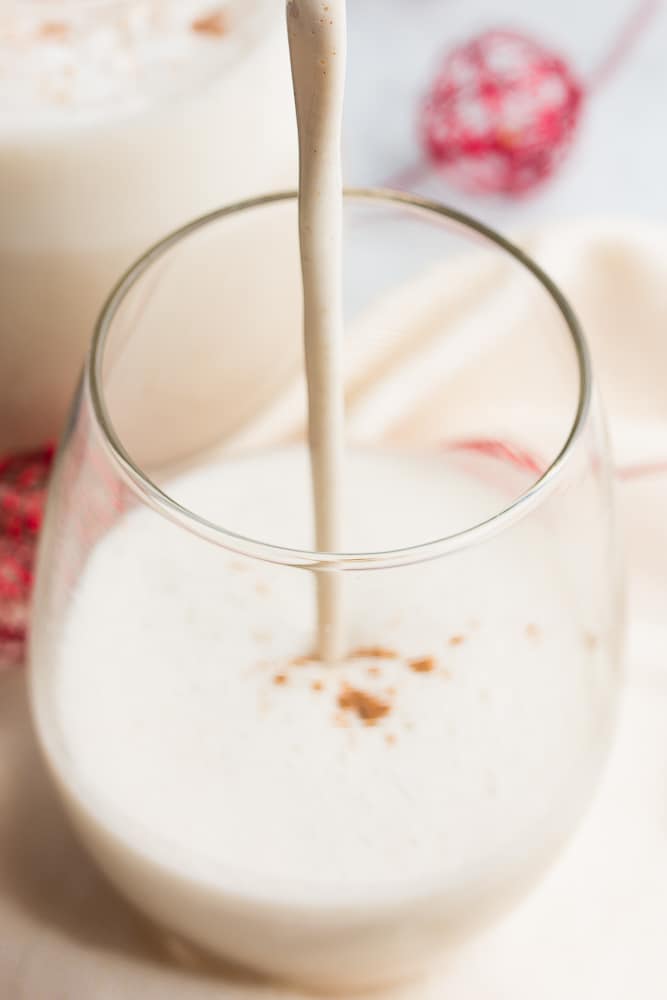 vegan eggnog being poured into a glass