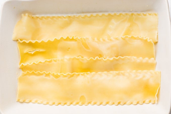 cooked lasagna noodles being layered