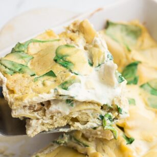 piece of white lasagna being taken out of casserole dish