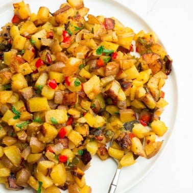 plate filled with breakfast potatoes, sprinkled with parsley.