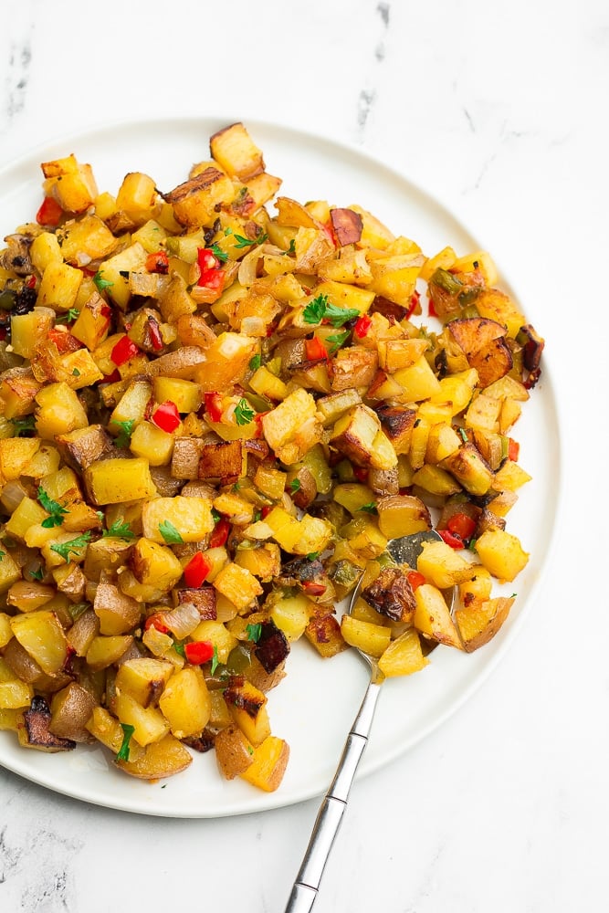 plate filled with little cooked potatoes, sprinkled with parsley. 