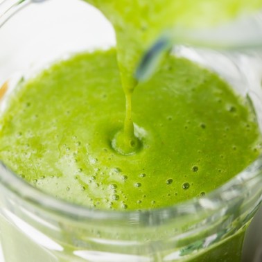 kale smoothie being poured into a cup from blender close up shot