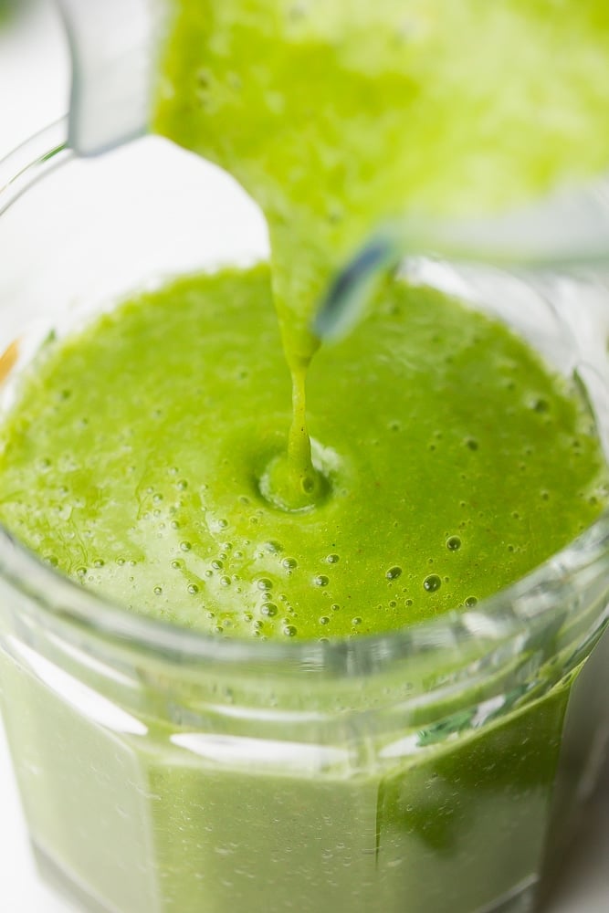 kale smoothie being poured into a cup from blender close up shot