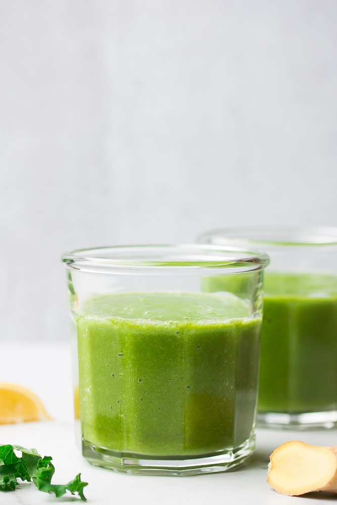 2 cups of kale smoothie with grey background