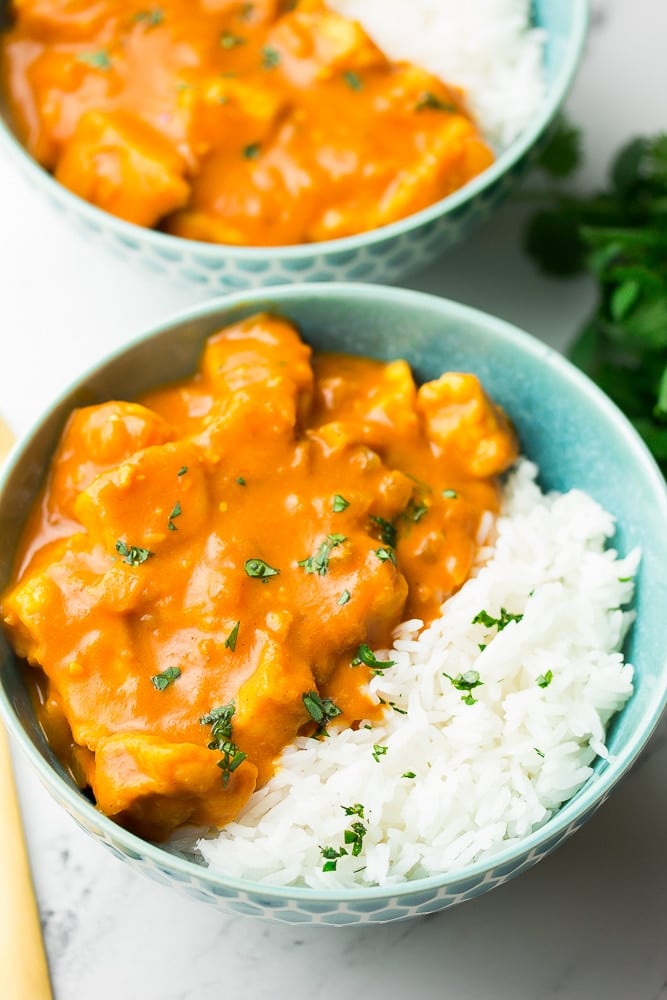 2 bowls of tikka masala with white rice