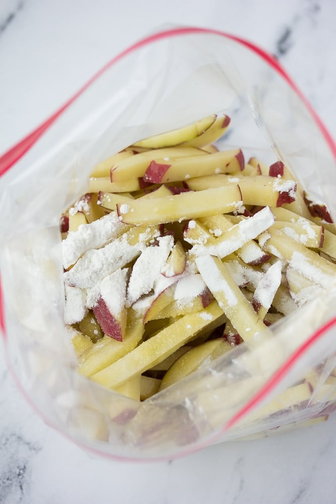 cut potatoes in a plastic bag with cornstarch and oil