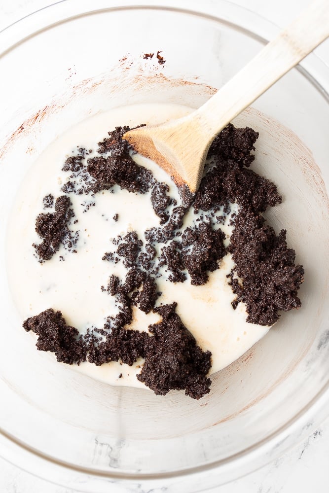 milk being added to bowl with chocolate dough