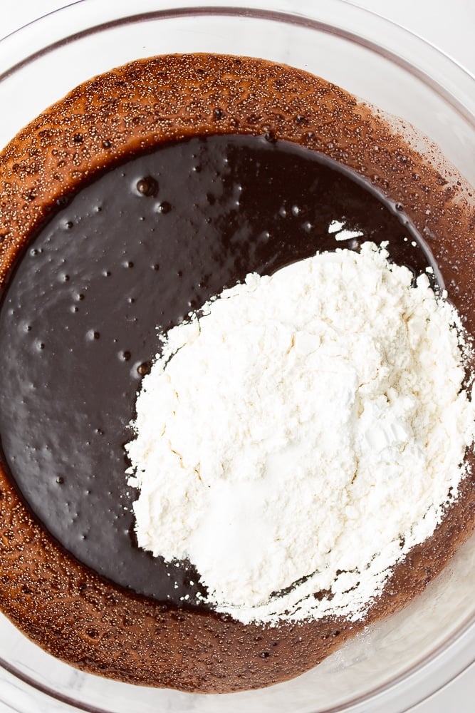 flour being added to bowl with chocolate