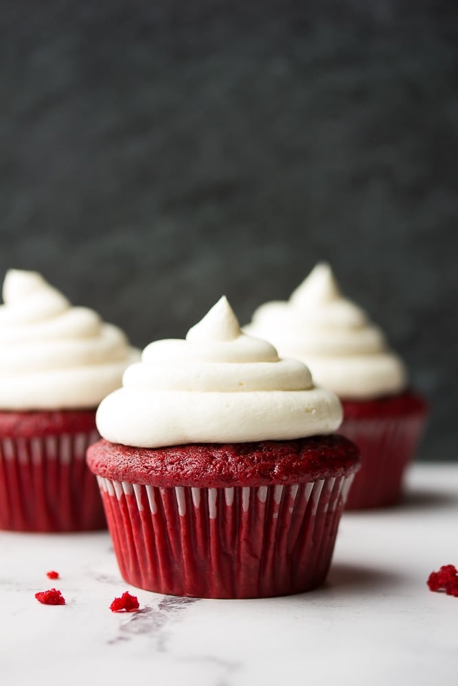 3 red velvet cupcakes with black background