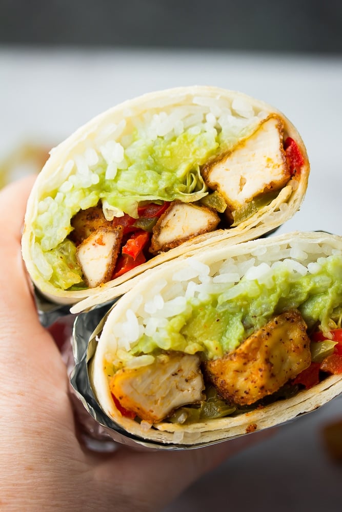 burrito with vegan chikn, lettuce, guac, black background