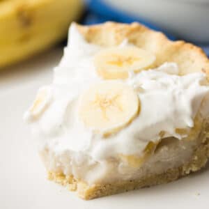 square image of creamy pie with bananas and bite taken out of it