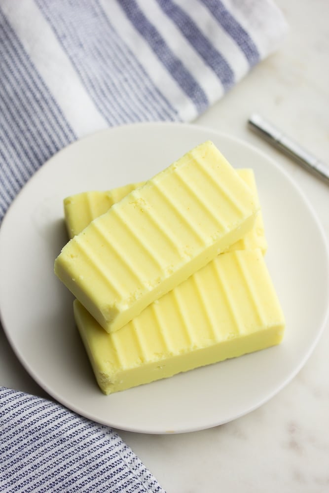 looking down on vegan butter on a white plate in sticks