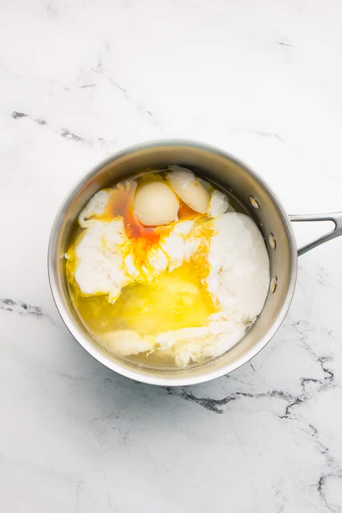 pan with ingredients like milk, lemon juice and butter, white marble background