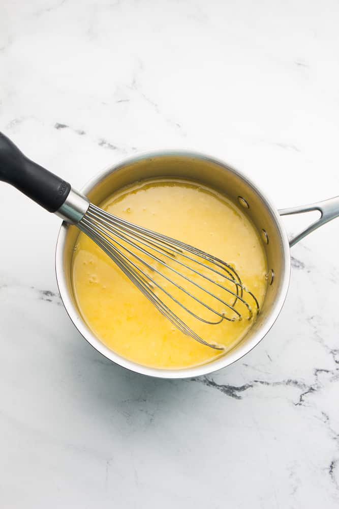 pan of yellow mixture with whisk in it