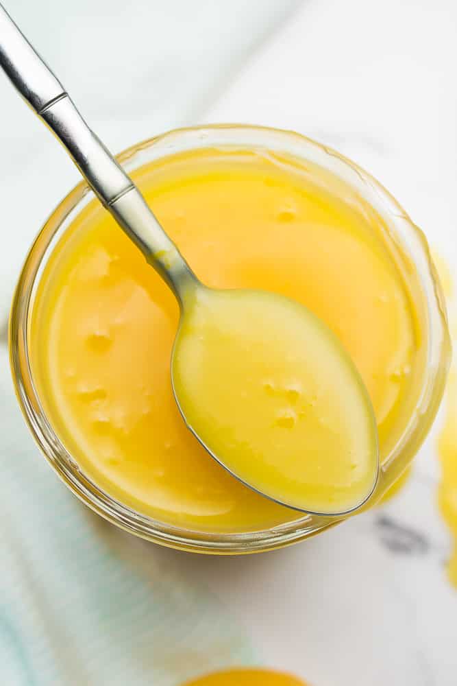 jar of vegan lemon curd with a spoon sitting on top