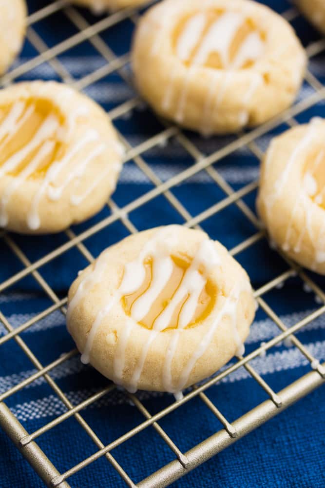 a close up of a few lemon shortbread cookies on a cooling rack on top of a blue towel