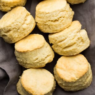 square photo of a group of buttermilk biscuits on a gray towel