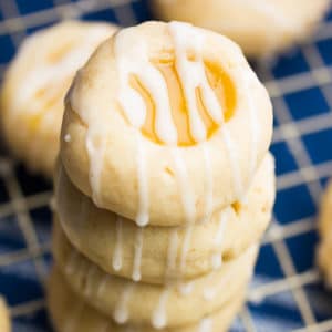 square image of lemon shortbread cookies stacked up on top of a blue towel