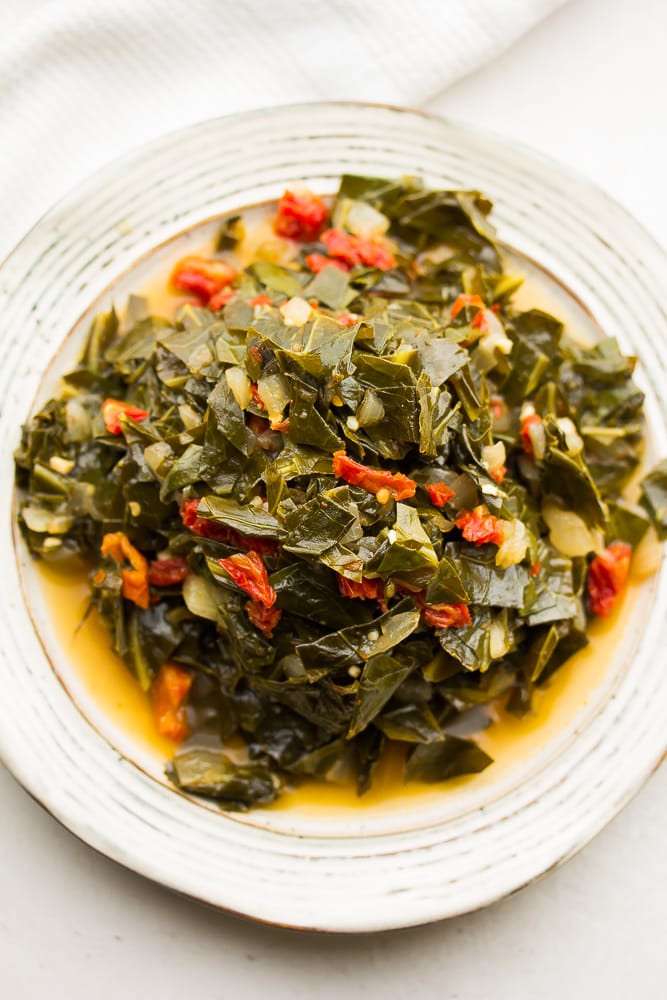 plate full of cooked collard greens with sun dried tomatoes