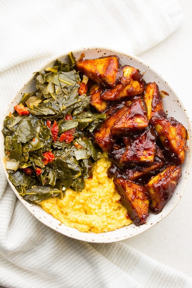 bowl with bbq tofu, grits and collard greens