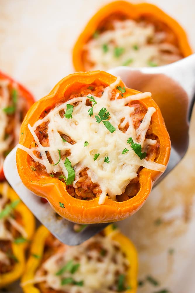 spatula holding a cooked bell pepper with stuffing in it