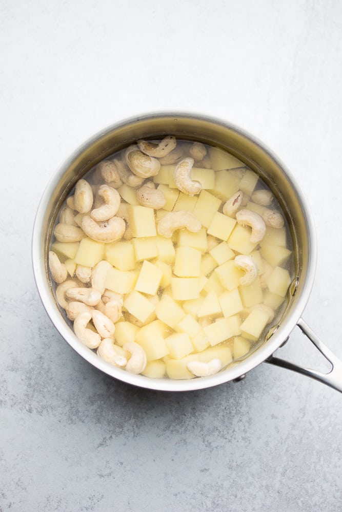small pot full of potatoes and cashews in water