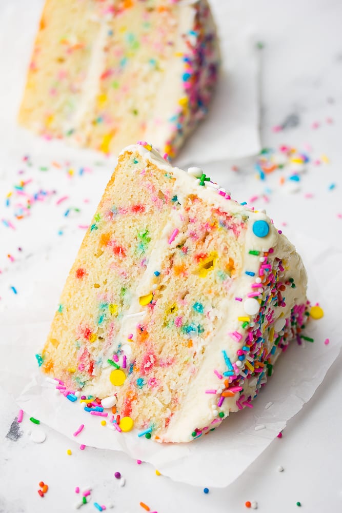 piece of cake with sprinkles on a white background