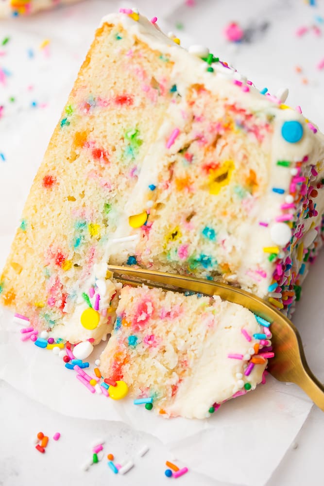 a fork cutting into a slice of vegan funfetti cake