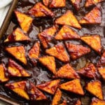 square image of tofu pieces with bbq sauce on them in a pan