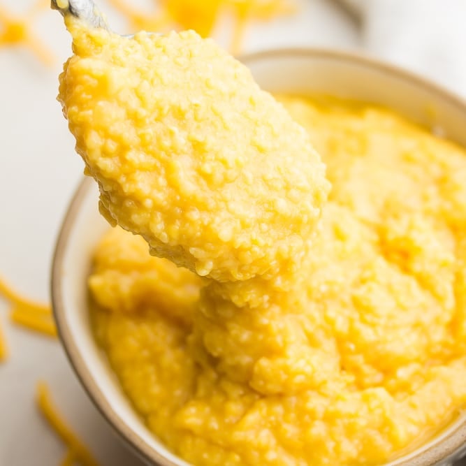 square image of cheesy mixture in a bowl with spoonful