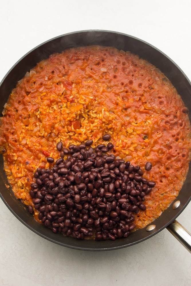 pan with red rice, adding black beans to it