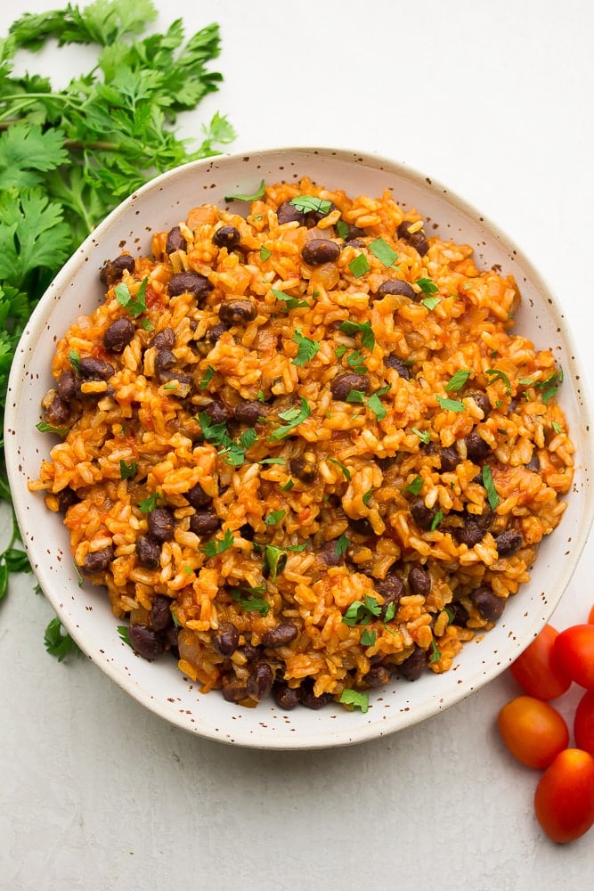 large bowl of spanish rice and beans on white background