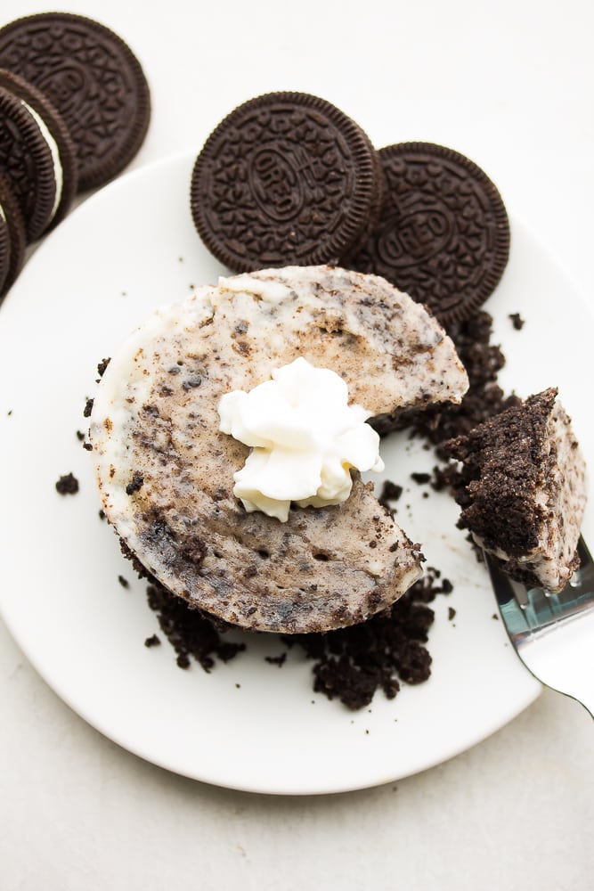 a mini oreo cheesecake on a plate with oreos around it